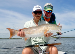 Long time fishing buddies celebrate a nice Redfish from Mosquito Lagoon.